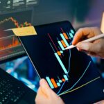 Person using a tablet to analyze financial charts for trading insights. Perfect for finance and technology themes.