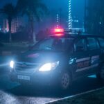 A Toyota police car patrols under city lights at night in Uttar Pradesh, India.