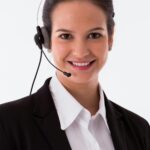 Confident female call center agent smiling at the camera with a headset.