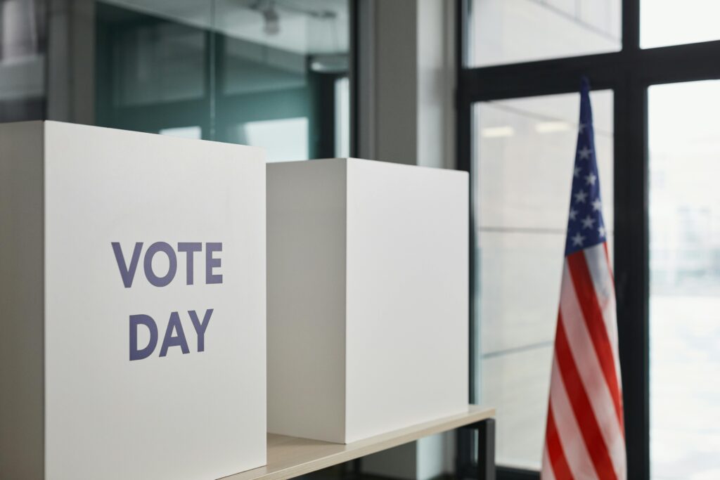 Voting booth setup with American flag, symbolizing election day.